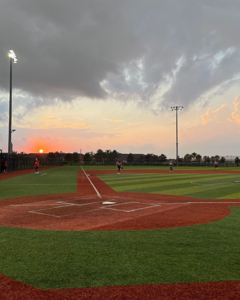 picture of an artificial grass softball field in arizona, sunset lighting. Installed by coyote sports turf