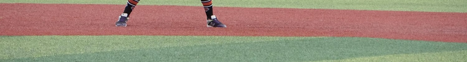 artificial grass baseball field in Phoenix Arizona, with a runner waiting to run to the next base.