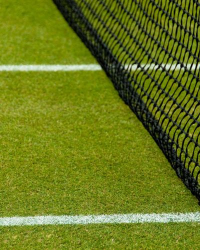 picture of artificial grass tennis court and net installed at an outdoor tennis facility by Coyote Sports Turf